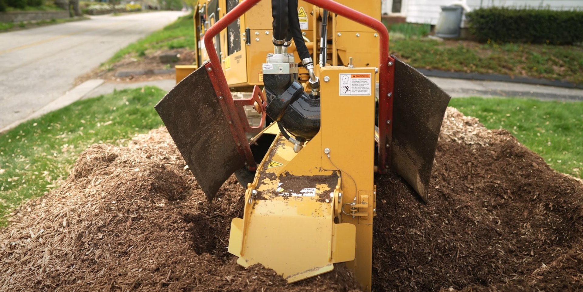 Heavy-duty stump grinder removing tree stump in Kirkland yard Professional stump grinding machine working on tree stump